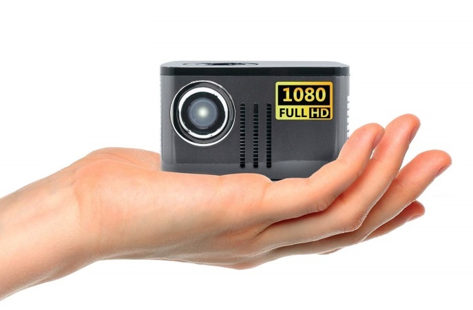 A person's hand holding an AAXA P7 Mini projector