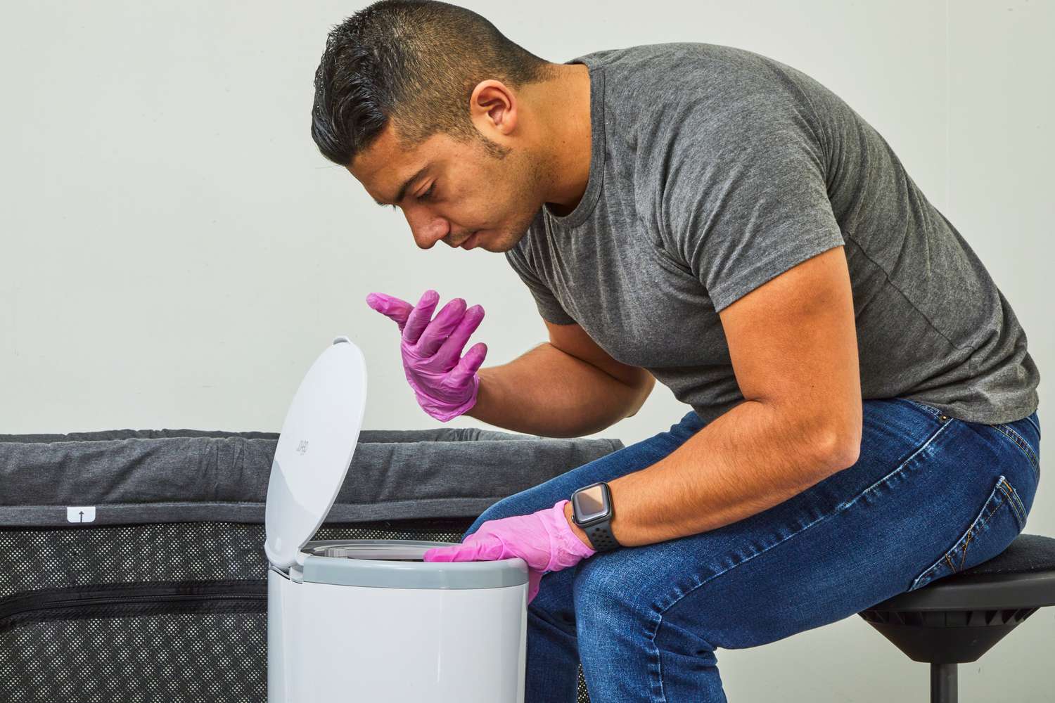 A person smells the Dekor Classic Hands-Free Diaper Pail