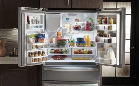 An open French door refrigerator loaded with food